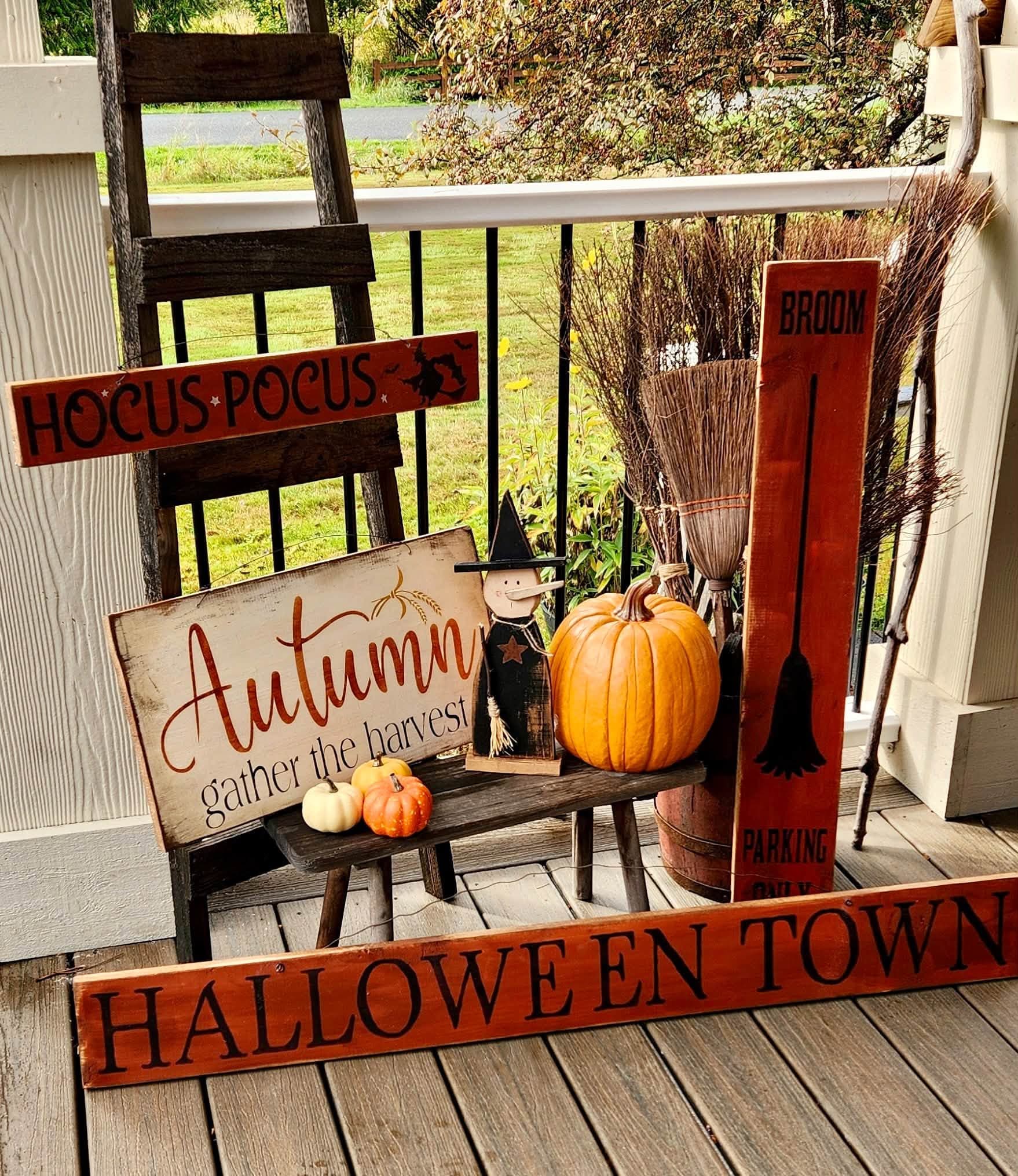 An autumn porch arrangement with harvest signs and a pumpkin