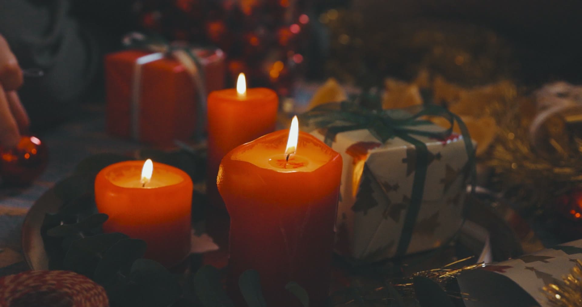 Warm candlelight over layered primitive and colonial displays inside the shop