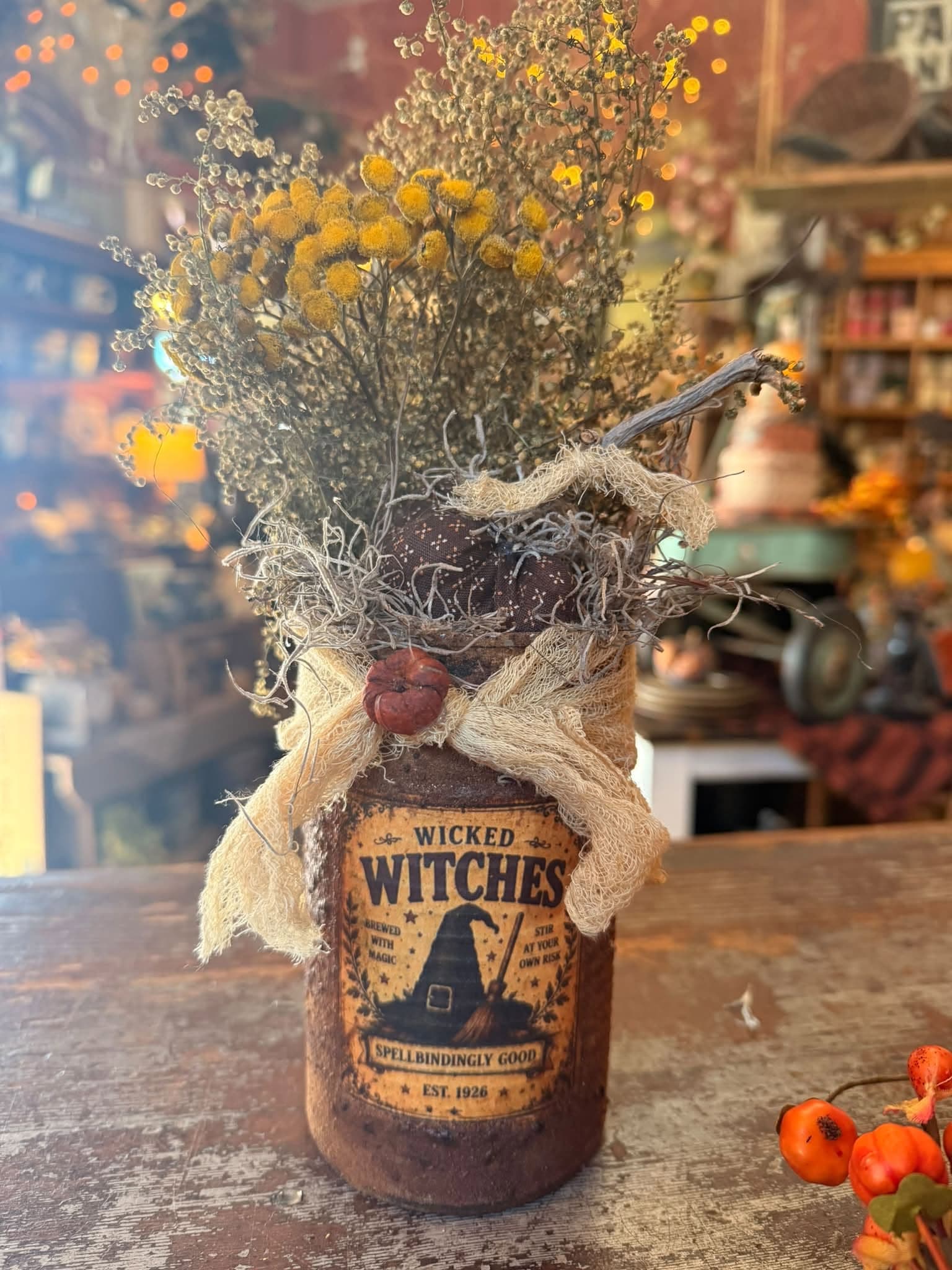 A folk-art candle with a hand-lettered label on the wooden shop counter